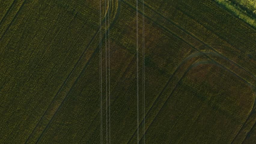 Top down shot of high voltage power lines running over a gravel road in rural America | Shutterstock HD Video #1101045255