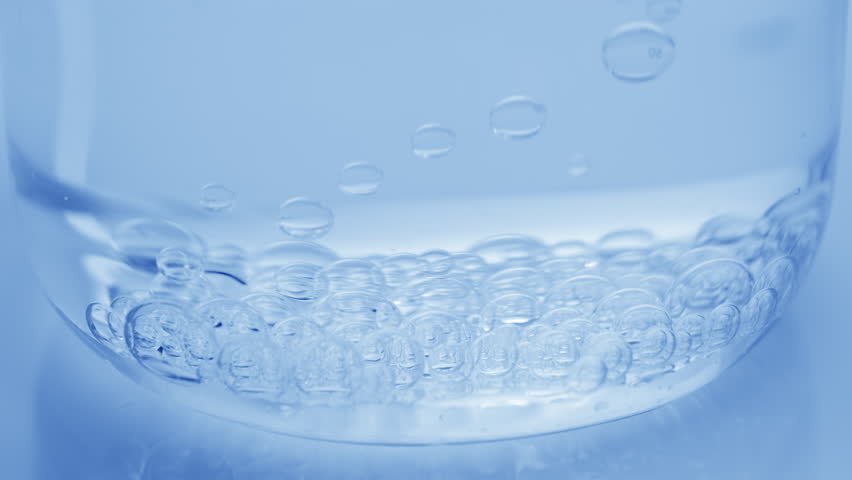 Extreme close-up shot of transparent bubbles sink to the bottom of beaker with water on blue background | Abstract skincare cosmetics with hyaluronic acid formulation concept | Shutterstock HD Video #1101045795
