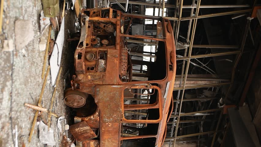 Metal bus frame. The rusty old body of the bus was turned into scrap metal by fire as a result of shelling by rockets and bombs. War brings destruction and death. War in Ukraine. Russian aggression.