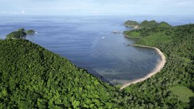 A stunning aerial footage of a forested Philippine island with breathtaking bays, beaches, and ocean views, perfect for travel video's.