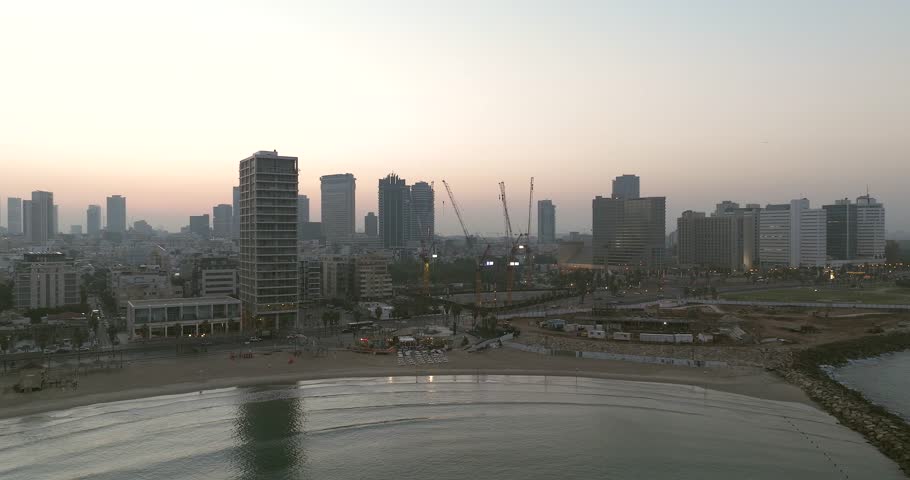 Tel Aviv coastline at sunrise with beautiful calm waters of The Mediterranean Sea, Waterfront hotels and light sun flare