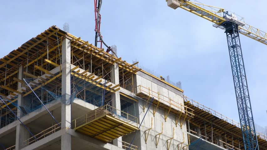 Close-up construction of a new modern residential complex. Workers pour concrete.