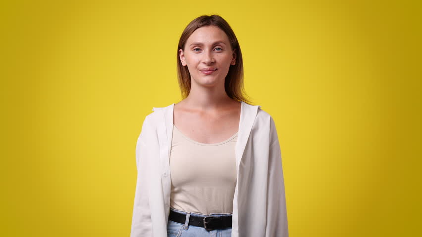 4k slow motion video of one woman who rejoices and crosses her arms over yellow background. | Shutterstock HD Video #1101053929