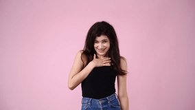 4k video of one girl who laughing and points a finger forward over pink background.