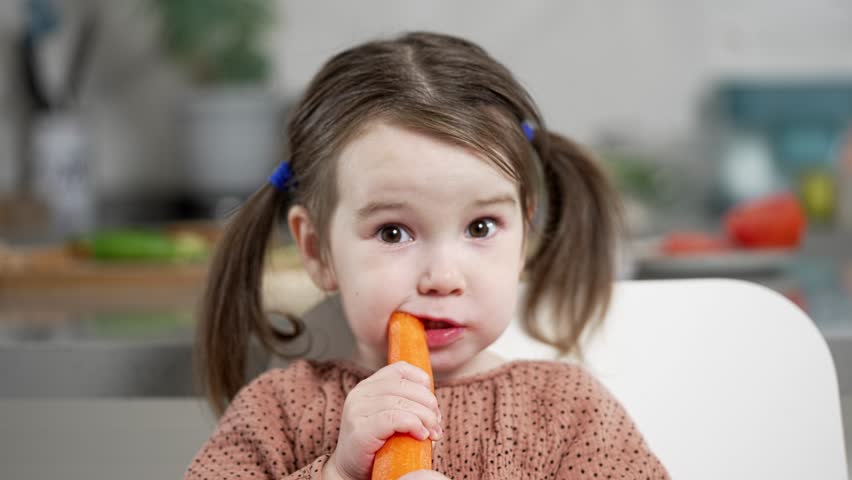Portrait of a Little Girl Eating a Carrot Royalty-Free Stock Footage #1101058379