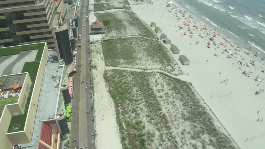 Fast aerial above white sand beach in Atlantic City, New Jersey on cloudy misty day