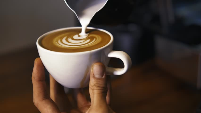 Hands of a worker serving a sparkling cappuccino in a cup in a coffee shop | Shutterstock HD Video #1101064553