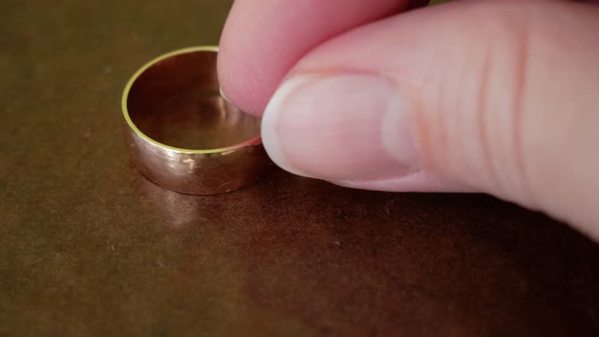 One golden wedding ring on brown background, | Shutterstock HD Video #1101066725