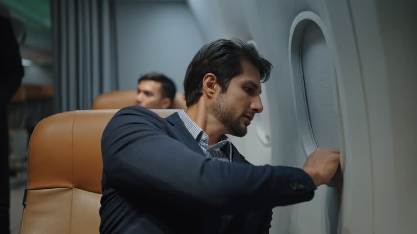 Indian businessman open the window of the plane to see the view outside from seat. Smile and enjoy the journey Royalty-Free Stock Footage #1101073105
