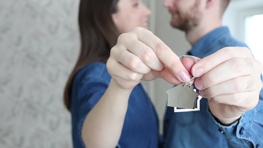 Portrait of happy married couple standing indoors and showing keys to new house. Royalty-Free Stock Footage #1101074831
