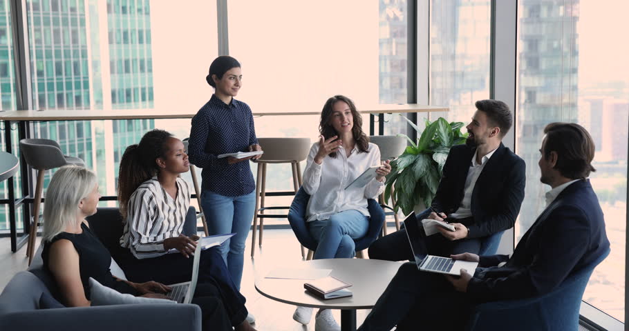 Diverse staff discuss collaborative project take part in group meeting, team leader share opinion at morning briefing with colleagues, gather together in modern office space. Brainstorming, teamwork Royalty-Free Stock Footage #1101076085