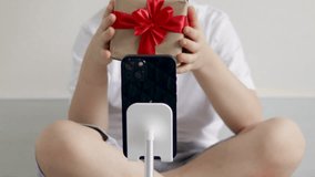 cute kid holding bouquet of tulips ,box gift sitting on bed giving,gift for mother march 8th women international day.child smelling tulip holding on nose.tulips in pants with phone calling spring - Powered by Shutterstock - Get 15% off with code: PIKWIZARD15