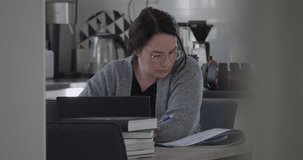 caucasian woman Works Remotely or studies at home with laptop and books