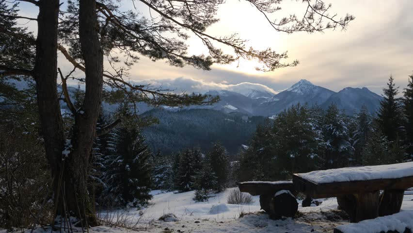 Winter mountain landscape with wooden seating and views of the forest scenery. Timelapse, Pan, 4K