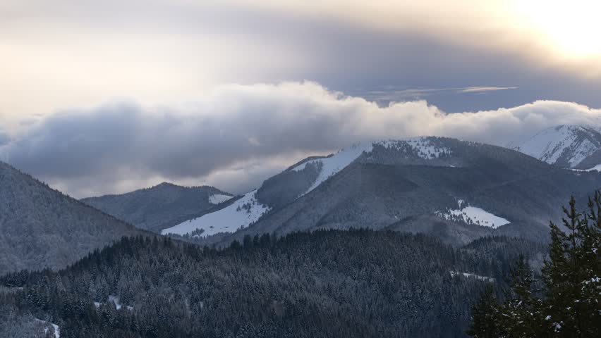 Clouds moving over the mountains during twilight in winter landscape. Tiemlapse Royalty-Free Stock Footage #1101087093