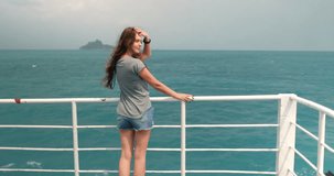 Long hair caucasian woman standing on the ferry deck and enjoying ocean view. Sailing on the ferry boat. Motivating Inspiring Slow Motion Video. Tourist use water transport to travel Thailand islands.