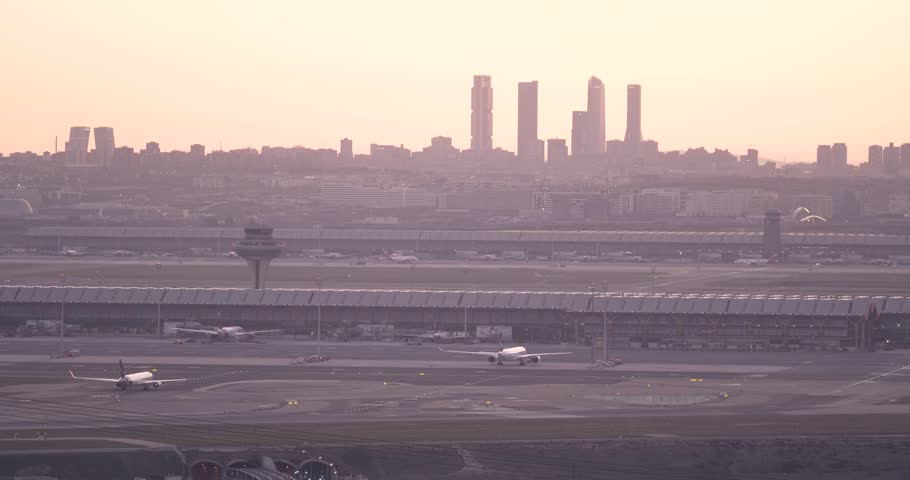 Timelapse View Of Madrid International Airport Control Tower and city skyline At Sunset against bright light orange glow | Shutterstock HD Video #1101088725