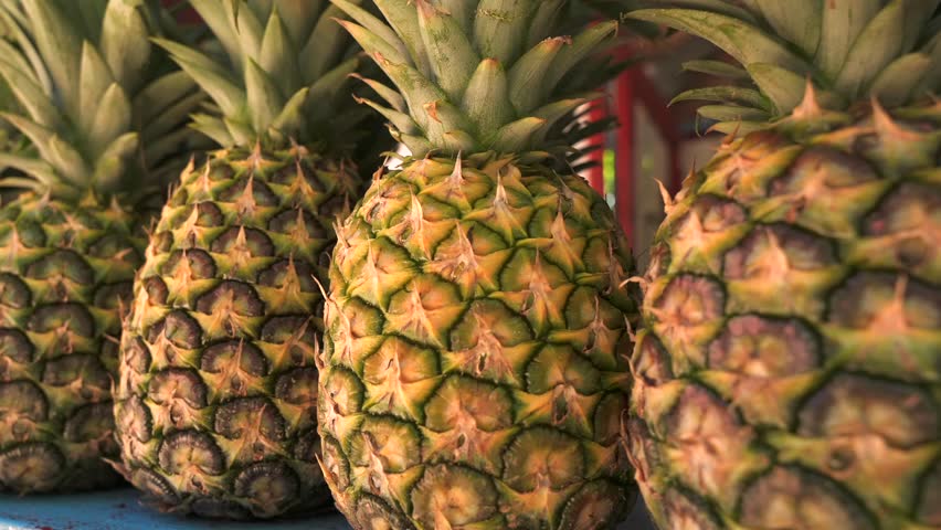 Close up of ripe pineapples on the counter of a fruit shop. Fresh fruits, juices and vitamins whole year in a tropical country.  Royalty-Free Stock Footage #1101090187