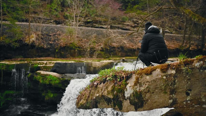 Male Photographer Taking Photos On Rocky Edge Of Cascading Waterfall, Babcock Mill Creek Falls, West Virginia