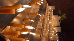 Candles are lit in the Catholic Church. Vertical video for the smartphone.