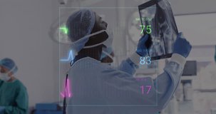 Animation of vital signs readings over african american male surgeon studying x ray. Medical and healthcare services concept digitally generated video.