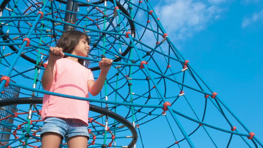 A child on a rope amusement ride against the sky. The concept of a developing playground.
