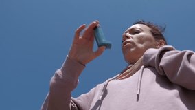 Woman with asthma. The woman experiences suffocation and uses an inhaler in the fresh air. - Powered by Shutterstock - Get 15% off with code: PIKWIZARD15