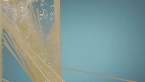 Slow motion of falling uncooked italian pasta Spaghetti into water on blue backgorund. Underwater spaghetti splash. Pasta spaghetti is falling into boiled water in slow motion - Powered by Shutterstock - Get 15% off with code: PIKWIZARD15