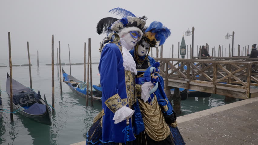 Two people with beautiful Venetian costumes pose during the Carnival in Venice