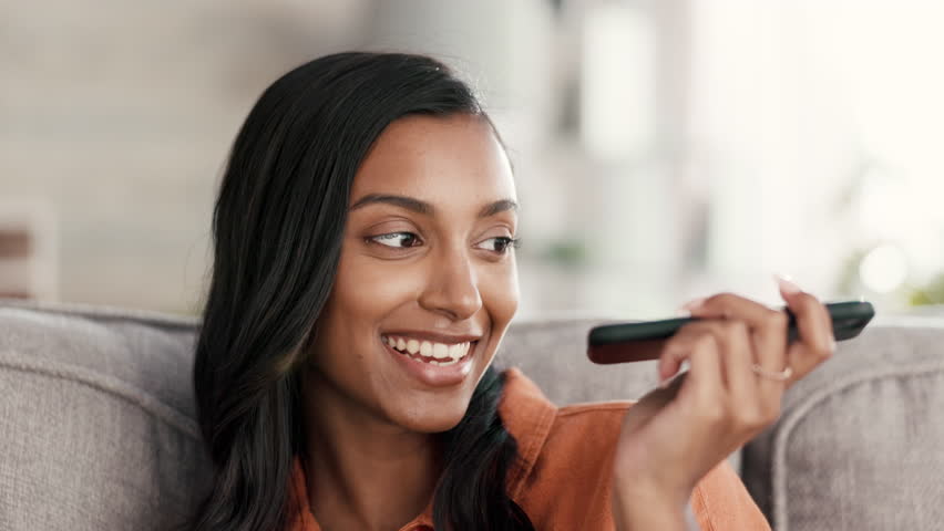 Woman, phone call and speaker on living room sofa for conversation, discussion or voice note at home. Female talking on smartphone in recording, networking or speaking about social life on couch | Shutterstock HD Video #1101116343
