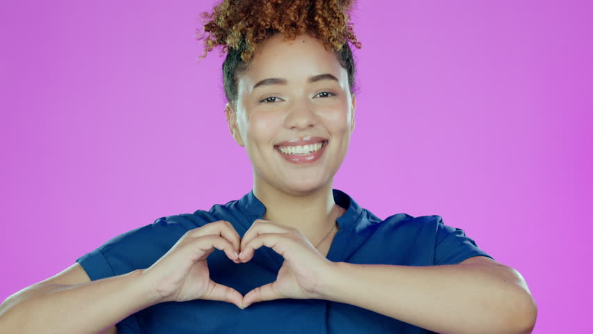 Face, heart and hands of woman in studio, color background and backdrop for care, kindness or emoji. Portrait of happy female model with finger shape for love, thank you and smile in support of peace | Shutterstock HD Video #1101116693