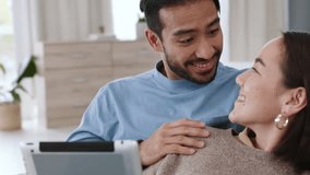 Asian couple streaming movies on tablet, watch funny video on subscription service online and talking about social media notification on sofa in home. Happy, comic and smile man and woman on tech - Powered by Shutterstock - Get 15% off with code: PIKWIZARD15