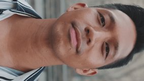VERTICAL VIDEO: Close-up of young man tourist looking at the camera - Powered by Shutterstock - Get 15% off with code: PIKWIZARD15