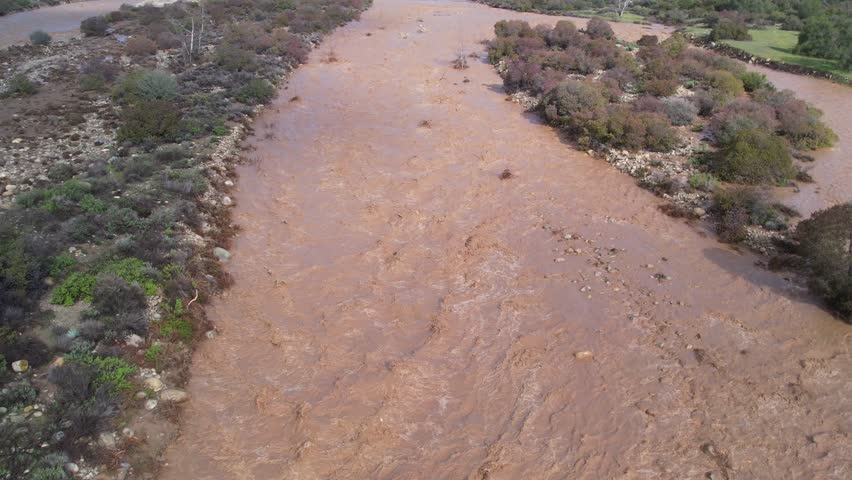 Ojai, california - circa 2023 - excellent aerial footage pulling away from the flooded ventura river by some misty mountains in ojai, california.