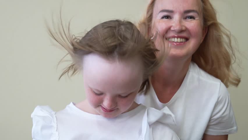 Close-up portrait of a girl with Down Syndrome and a woman. International Down Syndrome Day concept. Slow motion | Shutterstock HD Video #1101127395
