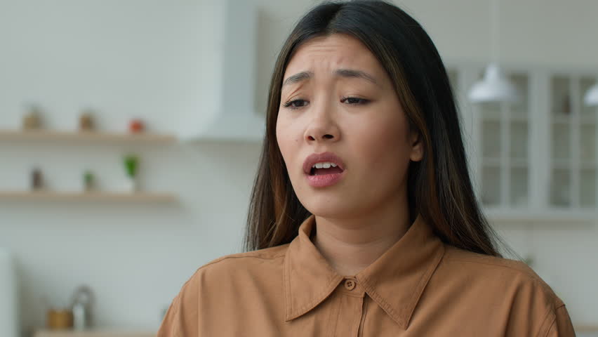 Unhealthy sick Asian woman girl sneeze cover face with hands in kitchen Japanese businesswoman suffer runny nose has allergy covid-19 symptom fever flu Korean lady feeling bad sneezing cold at home Royalty-Free Stock Footage #1101131067