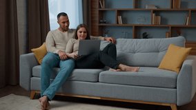 Diverse multiracial couple relax at home surfing online website on laptop using computer married woman wife and man husband talking buying retail goods shopping in ecommerce app spend weekend on couch - Powered by Shutterstock - Get 15% off with code: PIKWIZARD15