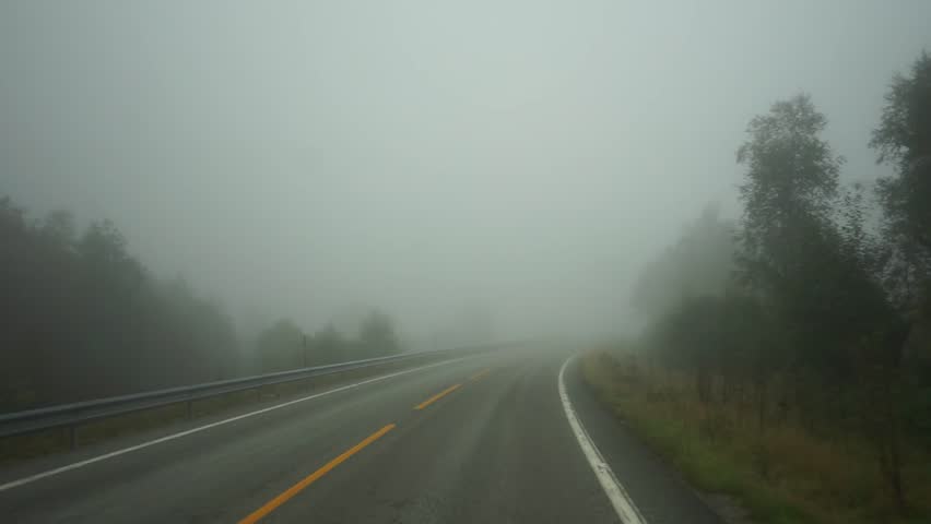 Driving an empty foggy road in Norway