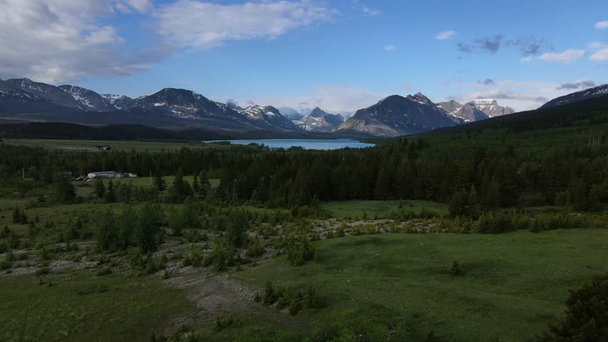 Glacier national park - circa 2022 - excellent aerial footage approaching st. mary lake at glacier national park, surrounded by snow-capped mountains.