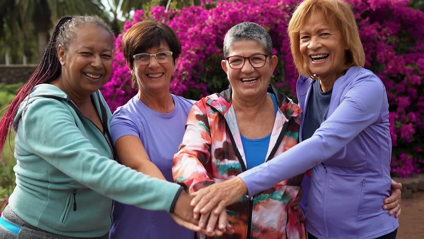 Multiracial senior women stacking hands at city park  Royalty-Free Stock Footage #1101134631