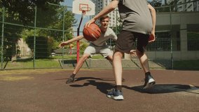 People playing street basketball during a warm summer day. Two teens playing a basketball match on an outdoors court during a sunny summer day. Attack and defence, missed shot. - Powered by Shutterstock - Get 15% off with code: PIKWIZARD15