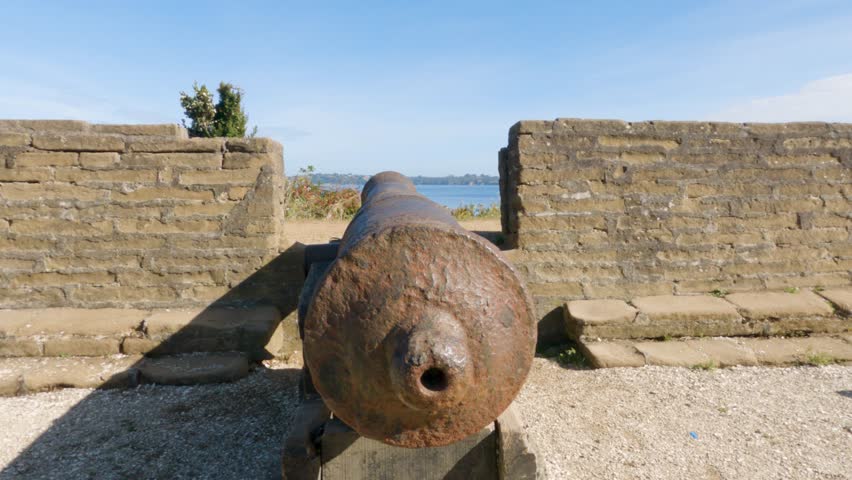An old and disused iron cannon
rusting away on a stone wall where it once fired. Cannons in fort Fuerte San Antonio in Ancud, Chiloe island, Chile