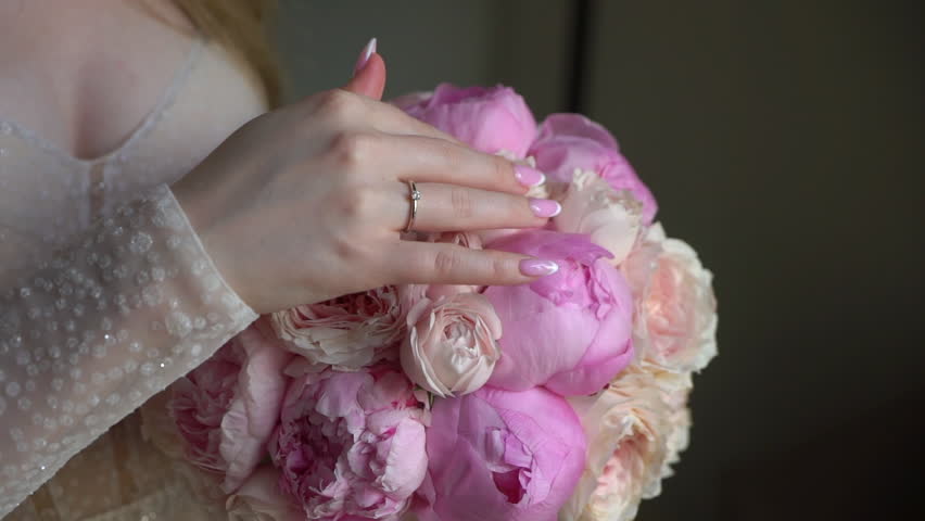 Female in dress hold in hands bouquet with ribbons of pink peony flowers. Gift for a woman, holiday, wedding bouquet of the bride. Floristics in summer. Bride in wedding day. | Shutterstock HD Video #1101145519