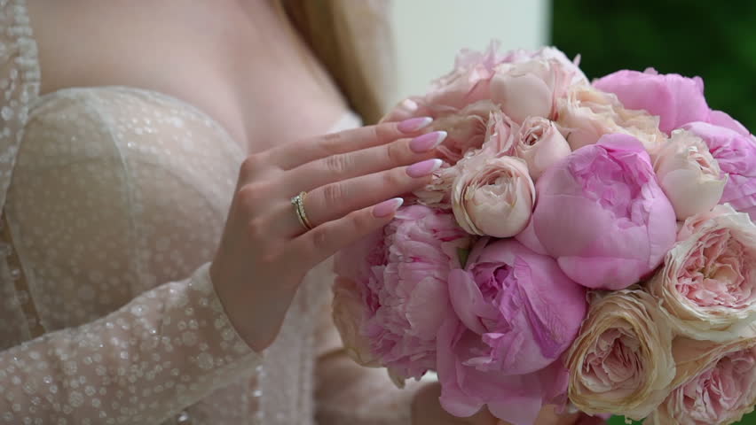 Female in dress hold in hands bouquet with ribbons of pink peony flowers. Gift for a woman, holiday, wedding bouquet of the bride. Floristics in summer. Bride in wedding day. | Shutterstock HD Video #1101145675