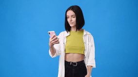 4k slow motion video of beautiful girl making selfie on blue background.