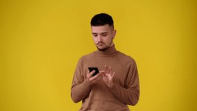 4k video of one man using phone over yellow background.