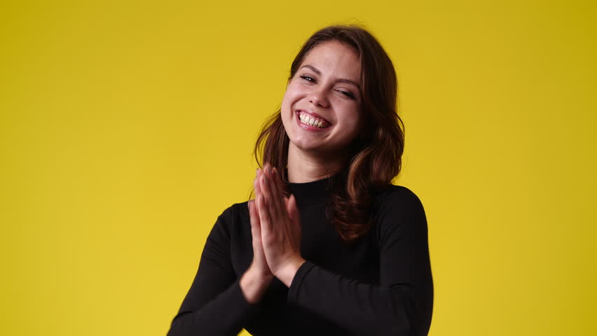 4k video of girl with cunning facial expression on yellow background.