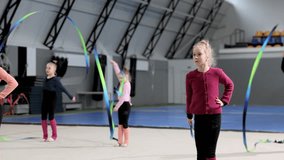 Competition preparation. Little girl, child, rhythmic gymnast training indoor, doing exercise with ribbon. Concept of sportive lifestyle, childhood, education, health, professional sport, championship