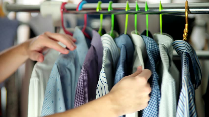 Choose Shirt On Wardrobe Hanger. Garments On Clothes Rack Wardrobe. Plucked Hanger With Clothes.Customer Choice Garment Rack With Shirt.Clothes Hanger Man Shirt. Apparel Consumerism. Dressing Wardrobe | Shutterstock HD Video #1101151421