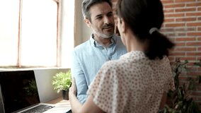 Middle-aged couple kissing and hugging passionately in a corner of the living room - Powered by Shutterstock - Get 15% off with code: PIKWIZARD15